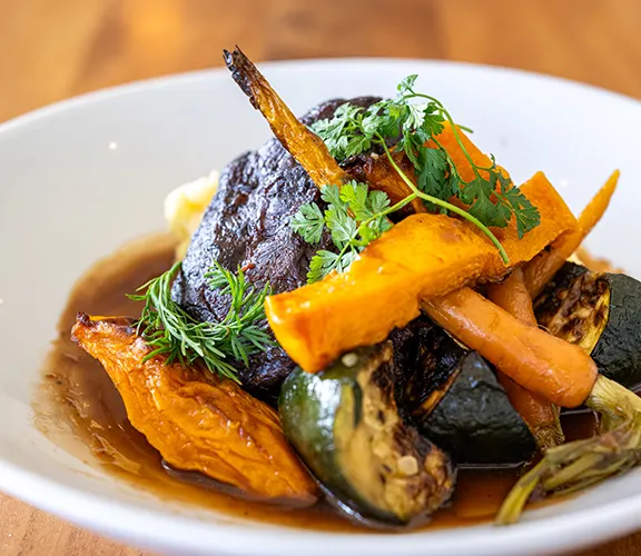 Plated main course with roasted vegetables and herbs