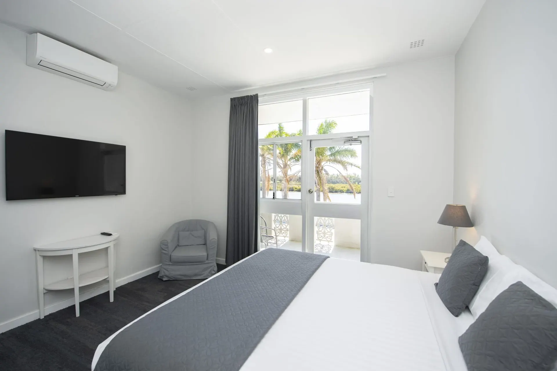 Guest room with a bed, television and sliding glass door