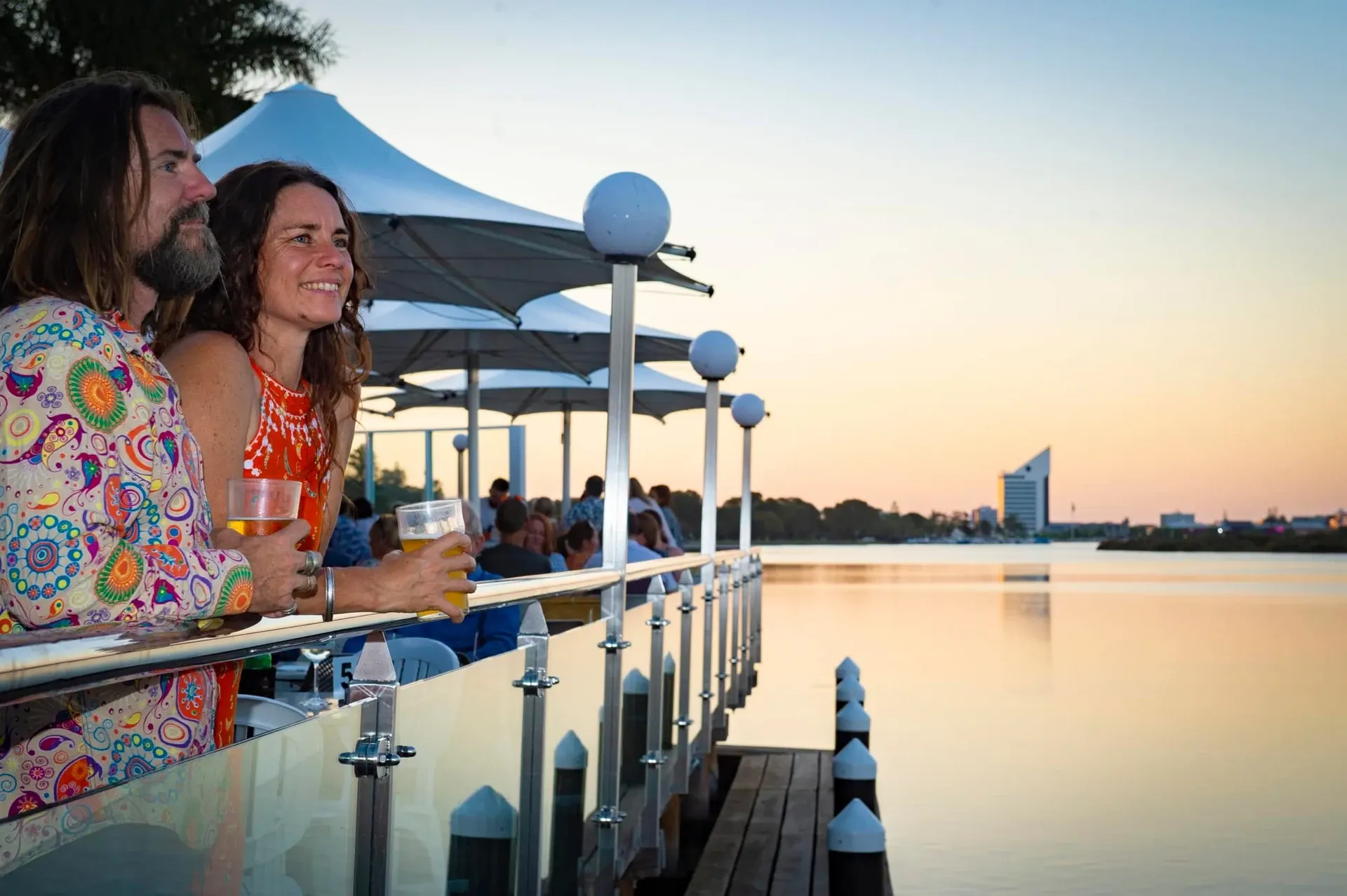 People enjoying drinks beside the water