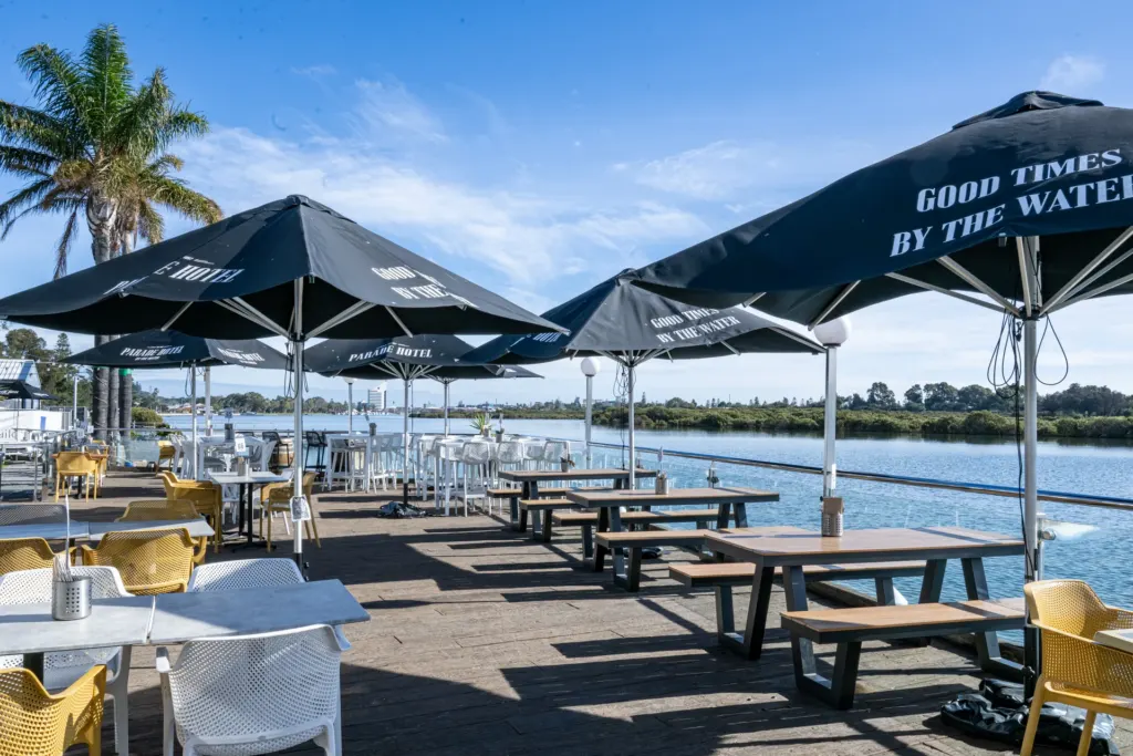 Waterfront tables and Parade Hotel umbrellas overlooking the river.