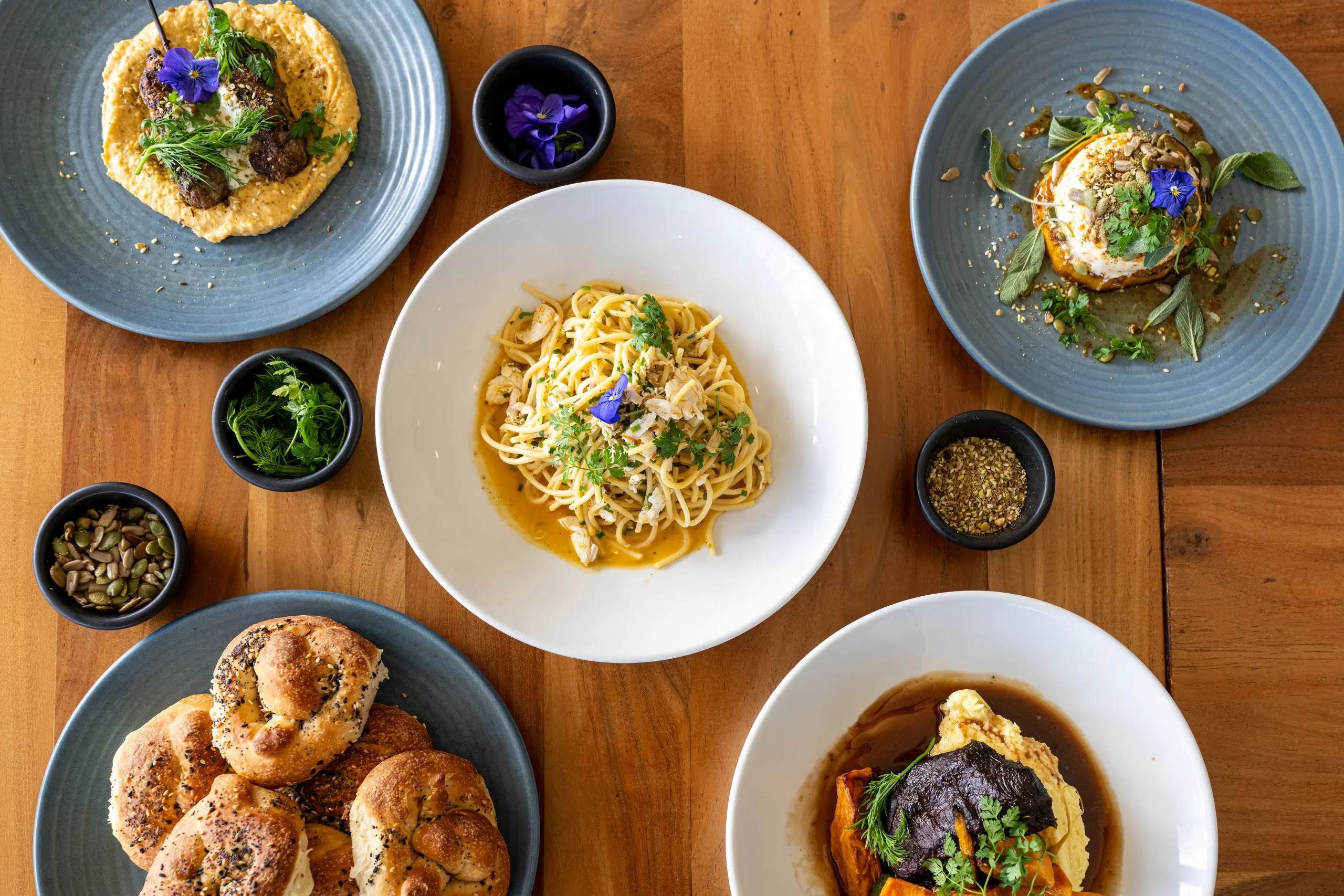 A selection of Parade Hotel bistro dishes, including pasta, roast vegetables and mains