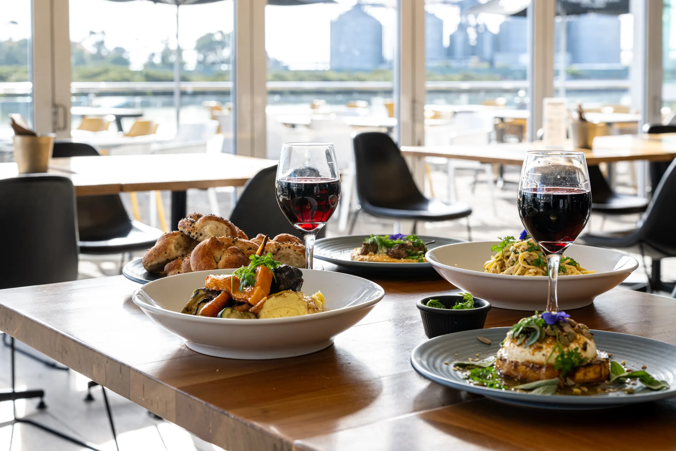 Bistro meals and glasses of wine beside the waterfront windows at Parade Hotel